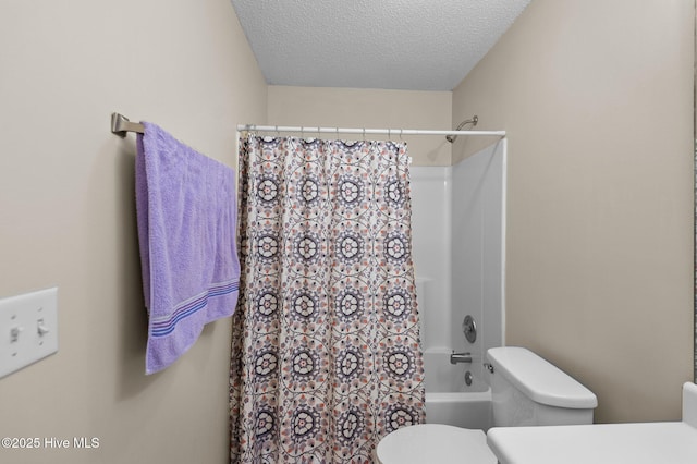 bathroom with shower / bath combination with curtain, a textured ceiling, and toilet