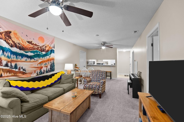 living room with light carpet, a textured ceiling, and ceiling fan