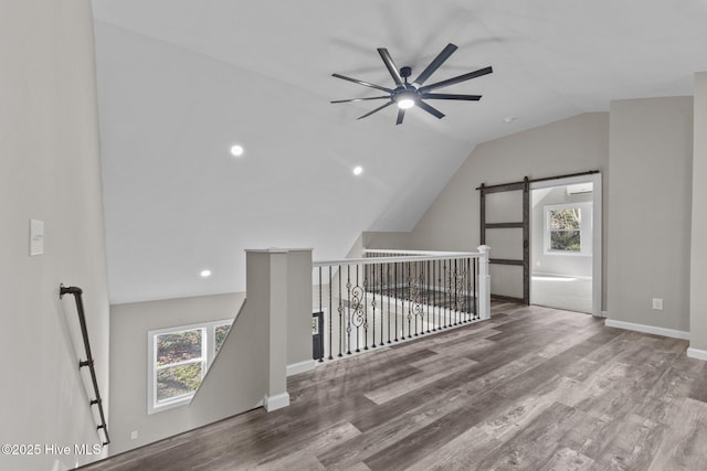 bonus room featuring a barn door, ceiling fan, lofted ceiling, and hardwood / wood-style flooring