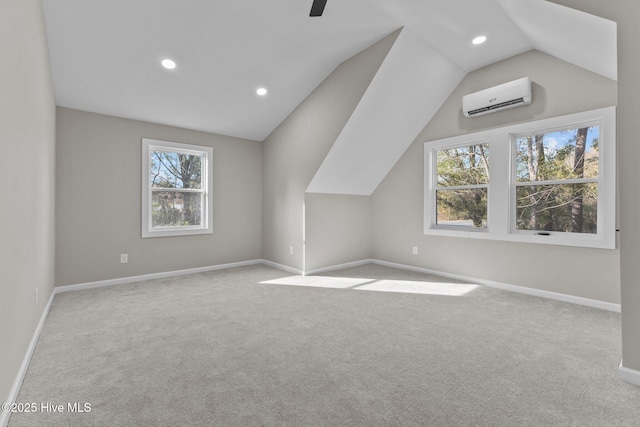 additional living space with ceiling fan, vaulted ceiling, light colored carpet, and a wall mounted AC