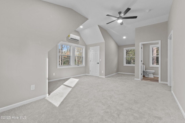 interior space with lofted ceiling, ceiling fan, light carpet, and a wall mounted air conditioner