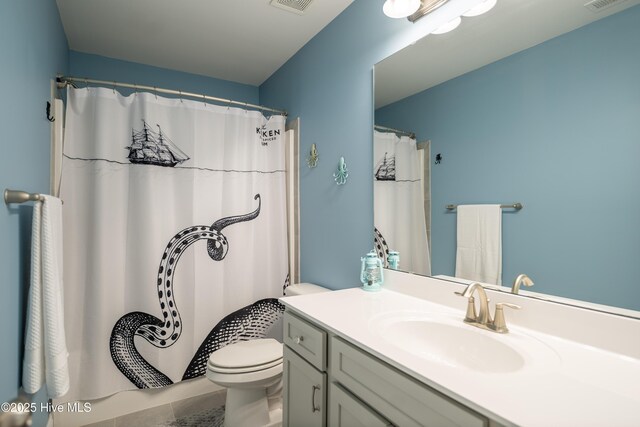 bathroom featuring tile patterned floors, ceiling fan, a shower with shower door, and vanity