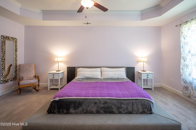 bedroom featuring ceiling fan, carpet floors, crown molding, and a tray ceiling