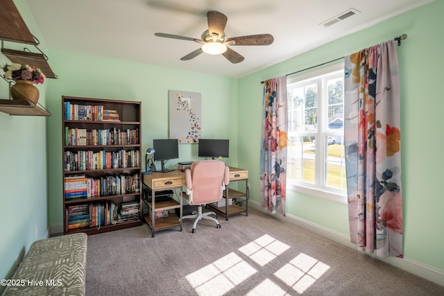 carpeted home office featuring ceiling fan