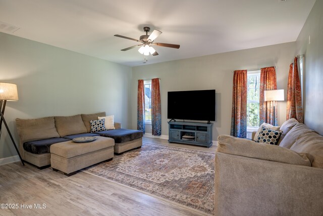 dining space featuring ceiling fan with notable chandelier and light wood-type flooring