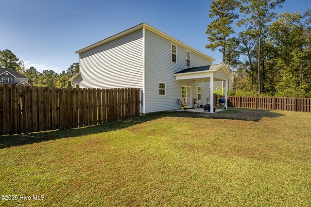 back of house with a yard and a patio