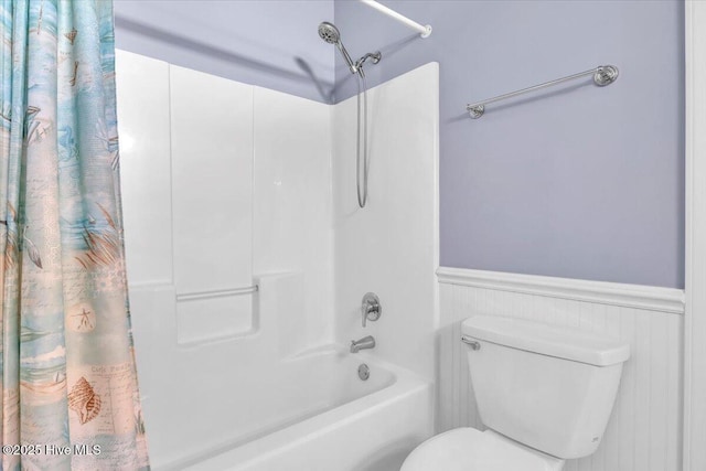 bathroom with shower / tub combo with curtain and toilet