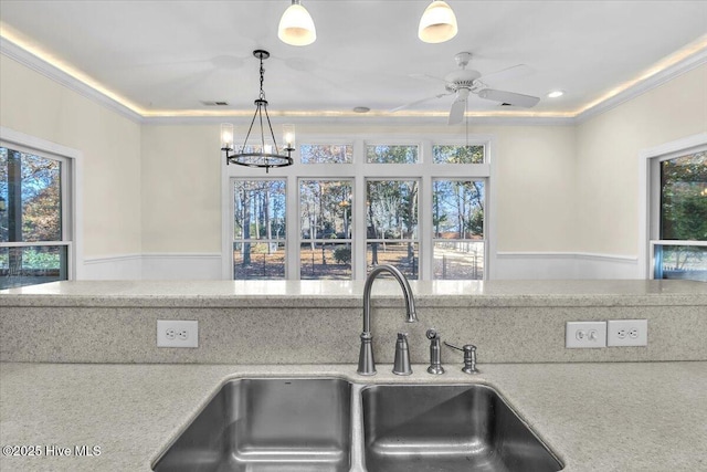 kitchen featuring pendant lighting, sink, a healthy amount of sunlight, and ceiling fan with notable chandelier