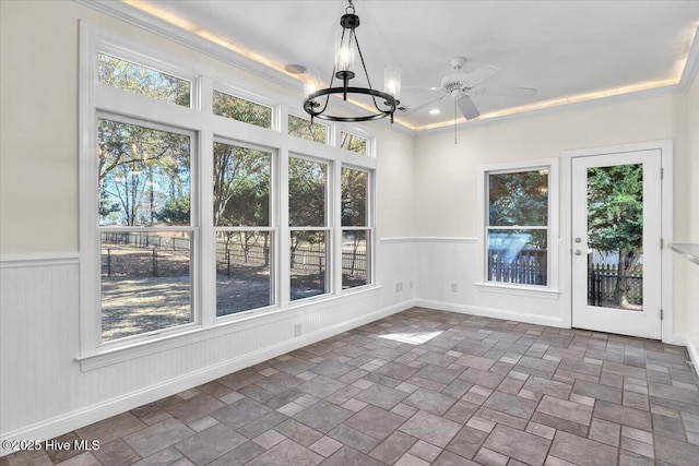 unfurnished sunroom featuring ceiling fan with notable chandelier