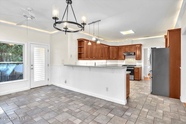 kitchen featuring ceiling fan with notable chandelier, crown molding, hanging light fixtures, kitchen peninsula, and stainless steel appliances