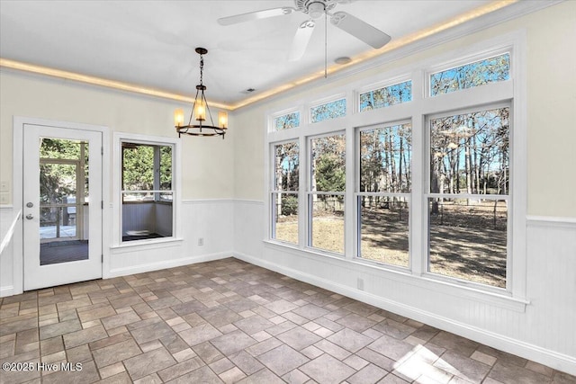 unfurnished sunroom with ceiling fan with notable chandelier