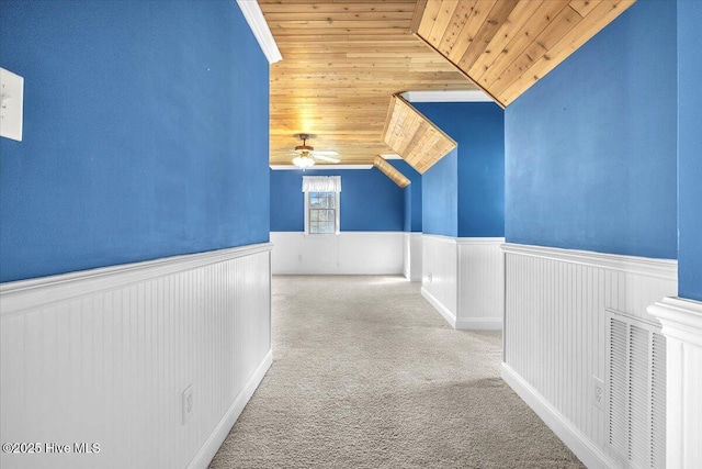 hall with wooden ceiling, light carpet, and vaulted ceiling