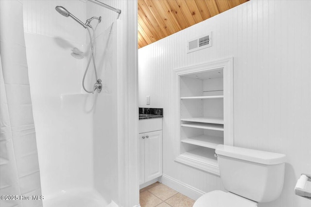 bathroom with vanity, vaulted ceiling, a shower, tile patterned flooring, and toilet