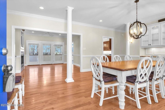 dining area featuring decorative columns, light hardwood / wood-style flooring, and ornamental molding