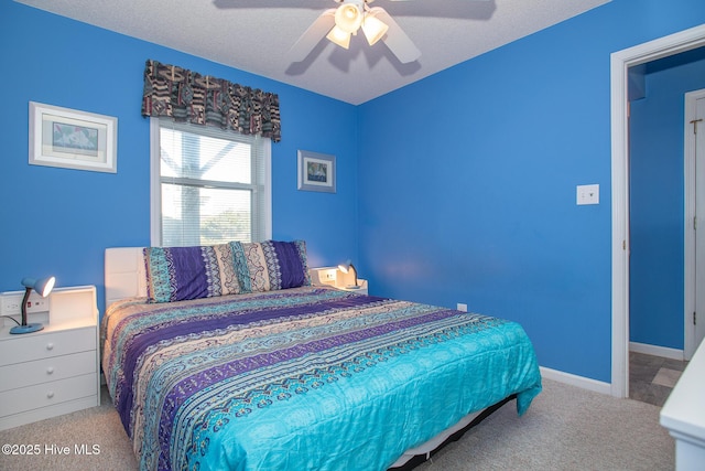 bedroom featuring a textured ceiling, ceiling fan, and light carpet