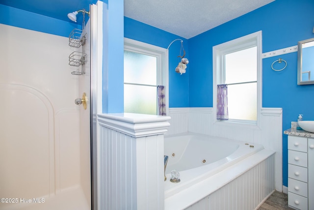 bathroom featuring vanity, shower with separate bathtub, and a textured ceiling