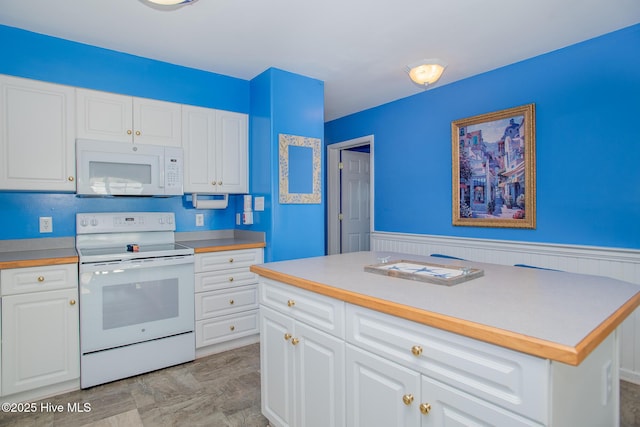 kitchen with white cabinets, white appliances, and a kitchen island