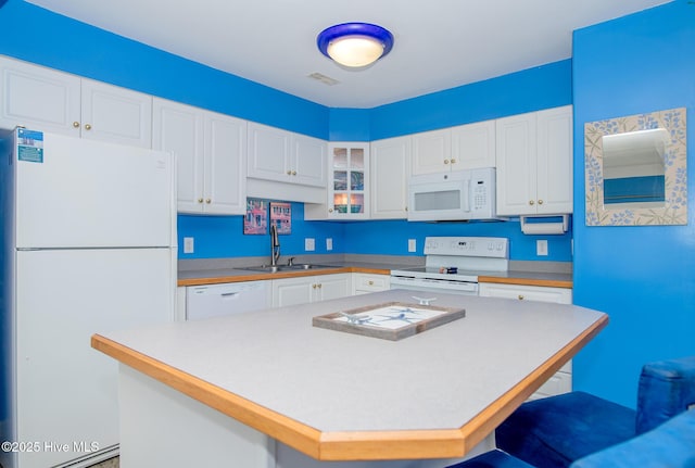 kitchen featuring white cabinets, a kitchen island, white appliances, and sink