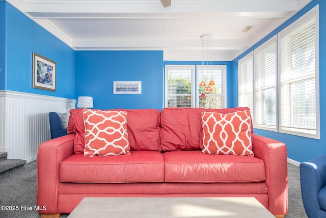 living room featuring beam ceiling and carpet flooring