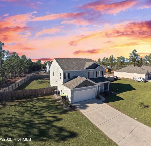 view of front of property featuring a yard, a garage, and central air condition unit