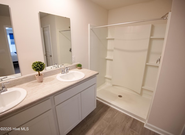 bathroom with hardwood / wood-style floors, vanity, and walk in shower