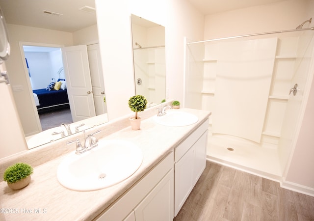 bathroom featuring a shower, vanity, and hardwood / wood-style flooring