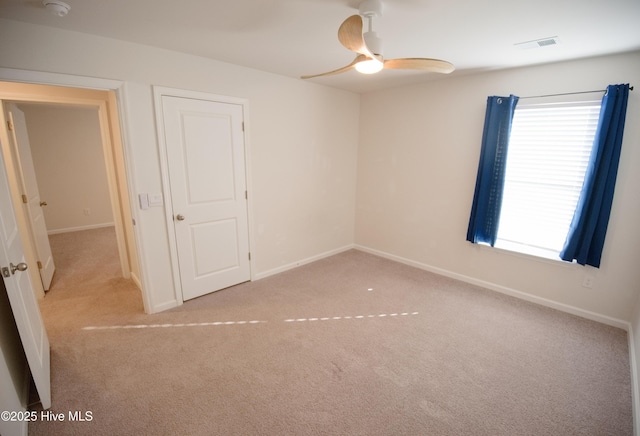 carpeted spare room featuring ceiling fan