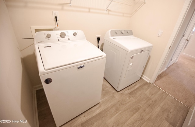 laundry room featuring washer and dryer and light hardwood / wood-style floors