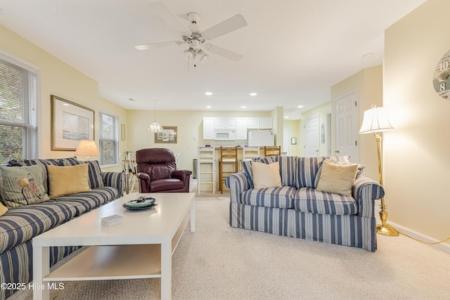 carpeted living room featuring ceiling fan