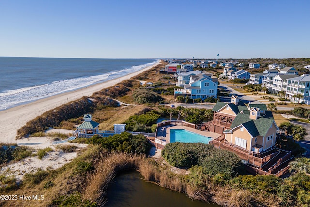 birds eye view of property with a water view and a beach view