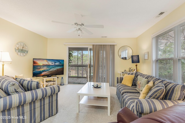 carpeted living room with ceiling fan