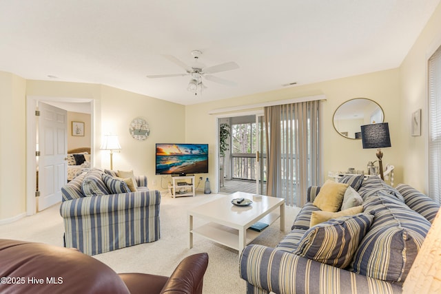 carpeted living room with ceiling fan