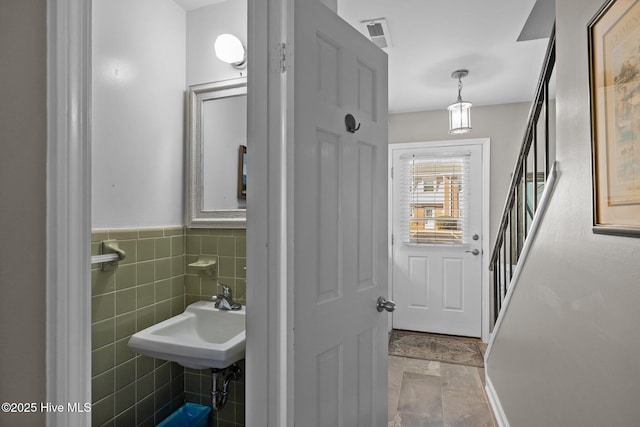 bathroom featuring tile walls and sink