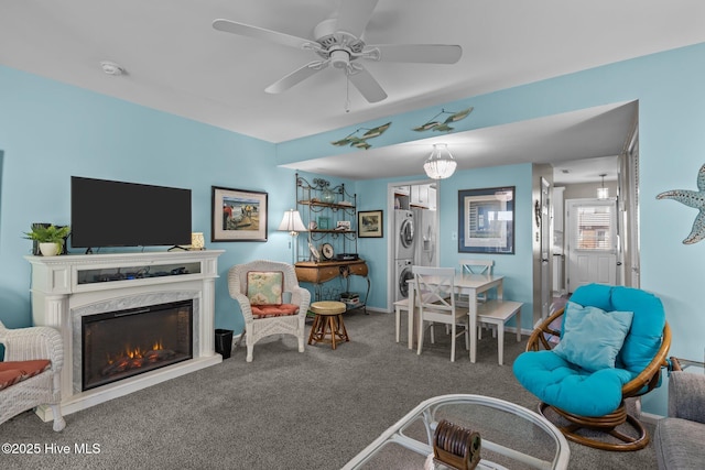 interior space with a fireplace, carpet floors, ceiling fan, and stacked washer / dryer