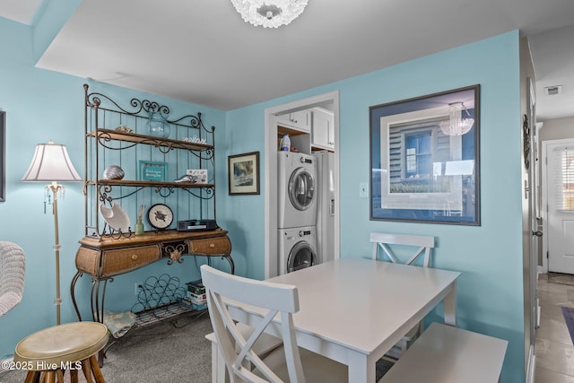 dining area featuring stacked washer and clothes dryer and light carpet