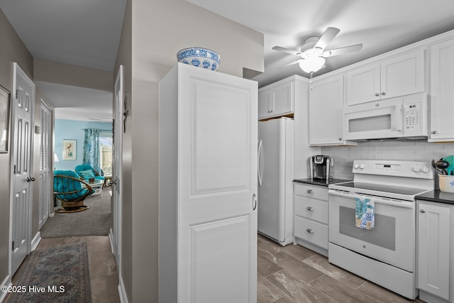 kitchen featuring white appliances, decorative backsplash, ceiling fan, and white cabinets