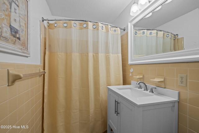 bathroom with tile walls, walk in shower, and vanity