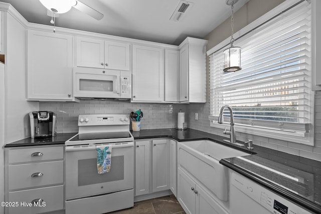 kitchen with decorative backsplash, white appliances, white cabinetry, and pendant lighting