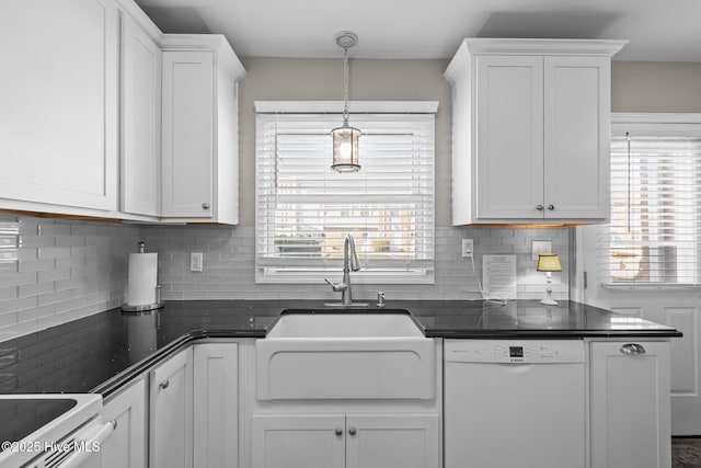 kitchen with white dishwasher, decorative backsplash, sink, white cabinetry, and decorative light fixtures