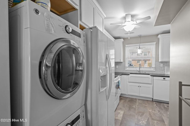 laundry area with sink, ceiling fan, and stacked washer / drying machine