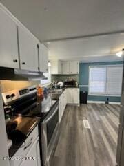 kitchen featuring electric stove, white cabinets, and hardwood / wood-style flooring