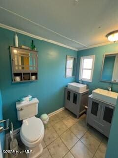 bathroom with tile patterned floors, crown molding, vanity, and toilet