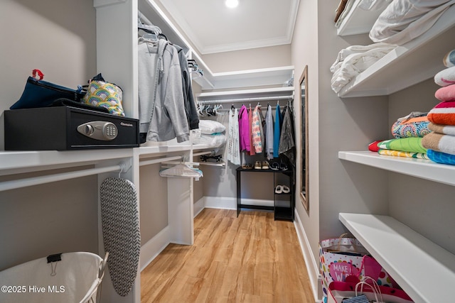 walk in closet with light hardwood / wood-style floors