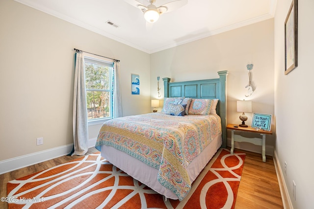 bedroom with crown molding, ceiling fan, and light hardwood / wood-style flooring