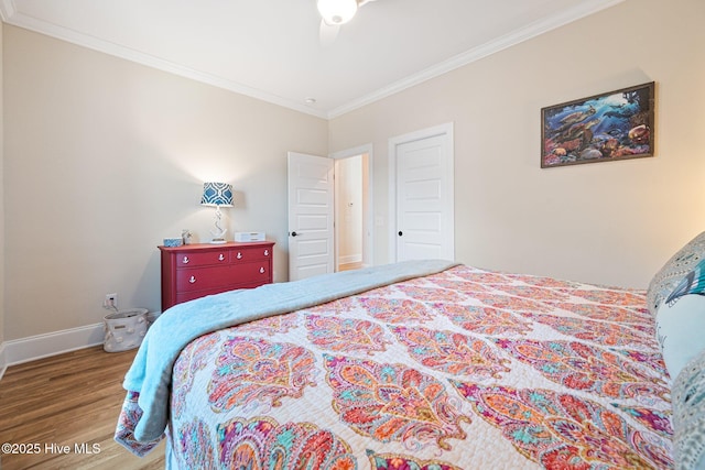 bedroom with hardwood / wood-style floors, ornamental molding, and ceiling fan