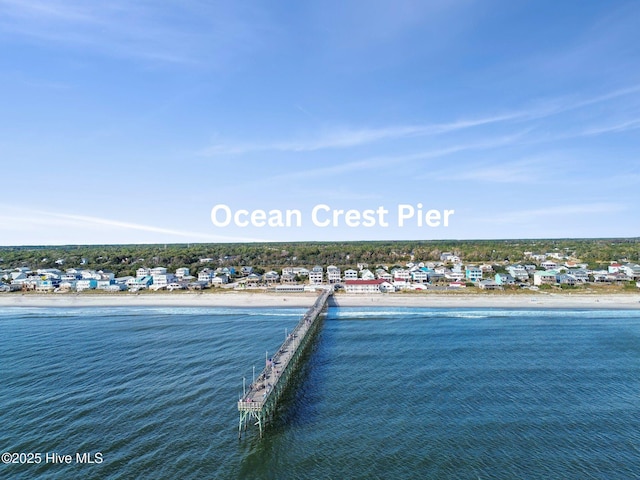 birds eye view of property with a water view and a beach view