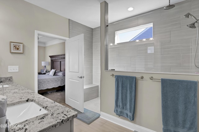 bathroom with vanity, a tile shower, and ornamental molding