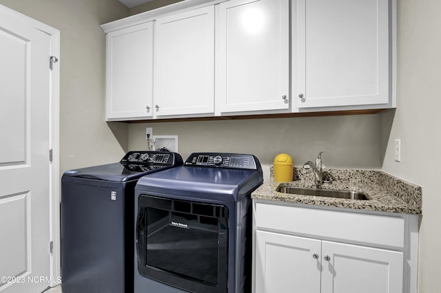 laundry room with cabinets, washer and clothes dryer, and sink