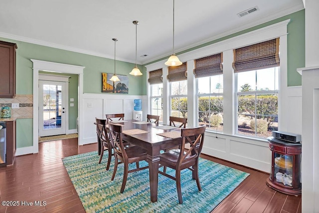 dining room featuring dark hardwood / wood-style flooring, ornamental molding, and a wealth of natural light