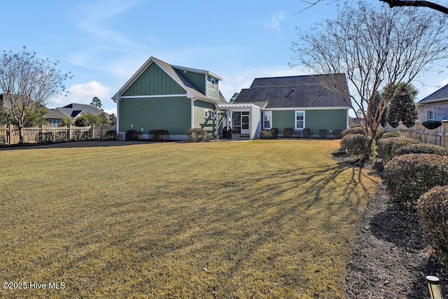 back of property featuring a lawn and a pergola